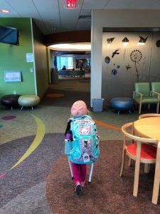Photo of Nora with her bag walking into the hospital