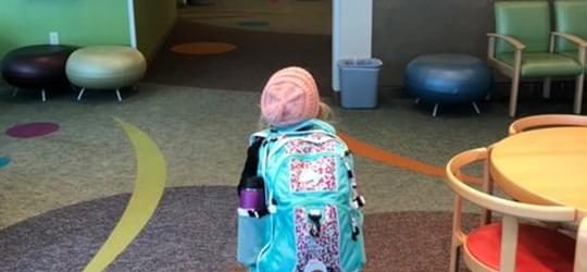 Photo of Nora with her bag walking into the hospital