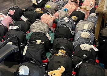 Rows and rows of Bags of Fun backpacks on the floor.