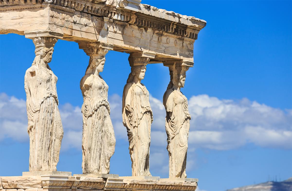 The corner of a Roman structure that shows 4 pillar statues of women.