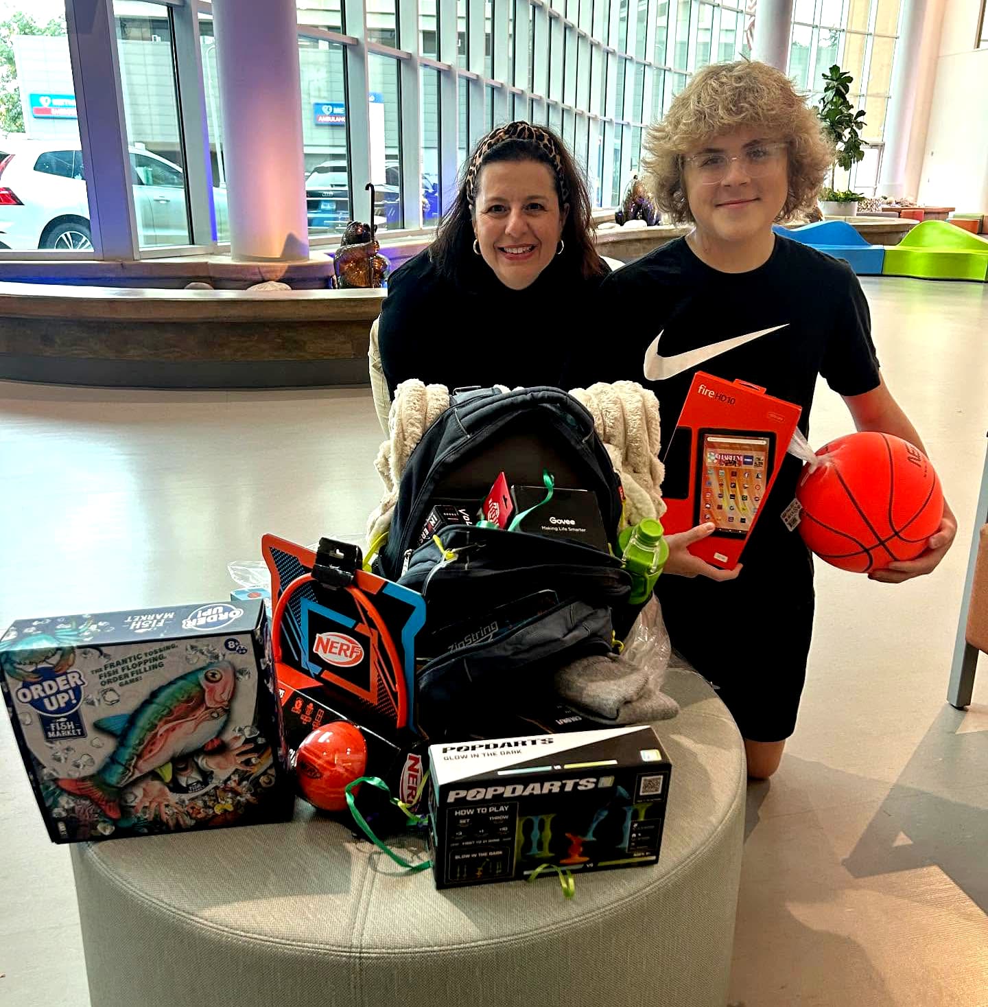 Woman and teen with a bag and all the toys in the hospital lobby.